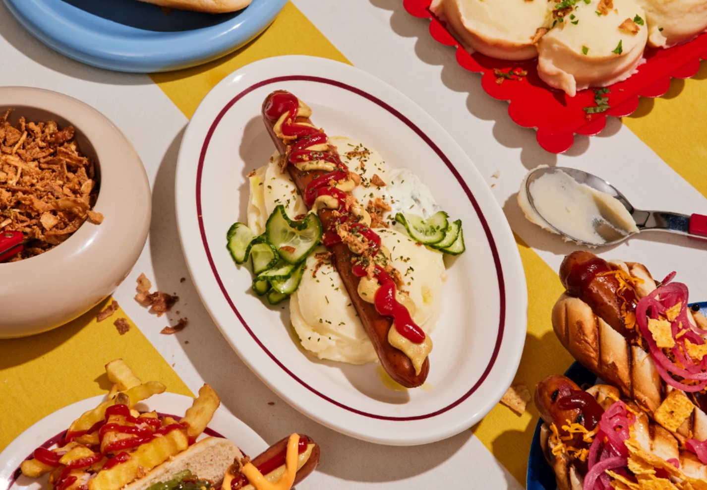 Atria plated hot dog with mashed potatoes, pickles, and sides